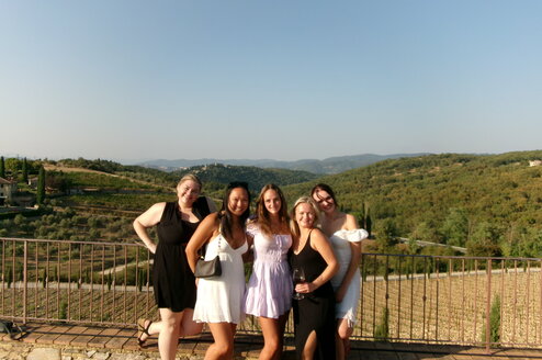 Students smiling and standing in front of a vineyard in Rome
